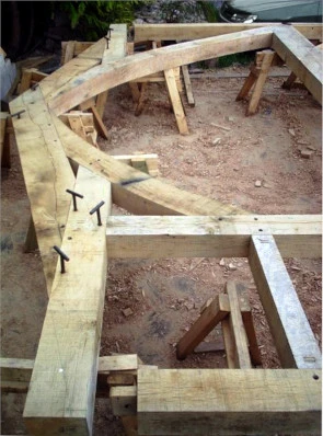 Green oak trusses laid out on trestles